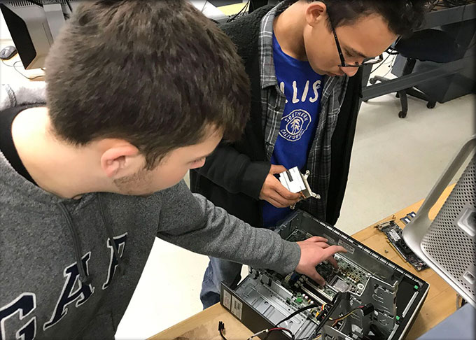 Two students repairing a computer in an Information Technology (IT) class