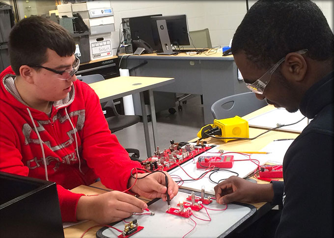 Two students performing electronic testing